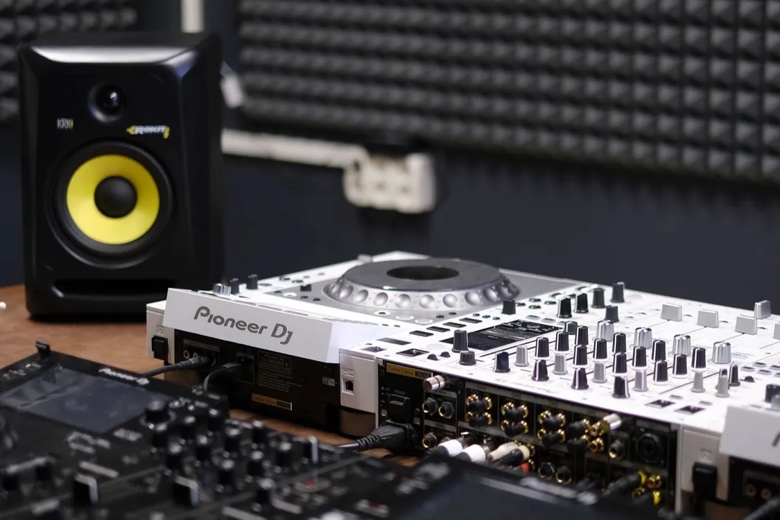 Professional Pioneer DJ controller and studio monitor set up and ready to go