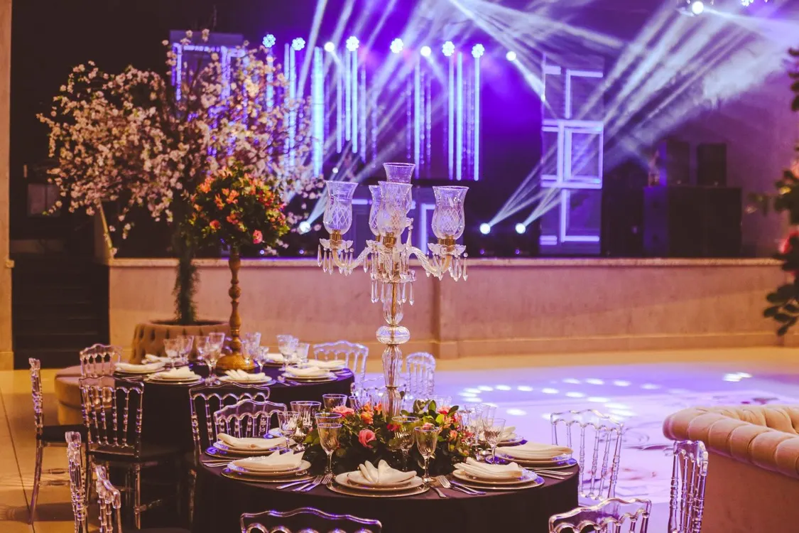 Elegant table setting with a crystal candelabra centerpiece and purple stage lighting