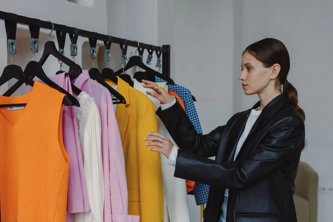 Woman browsing a colorful fashion collection in a modern boutique during a brand event